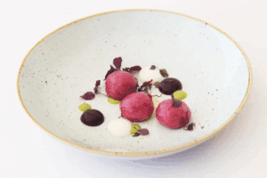 Pink gnocchi with a green core and ricotta cream