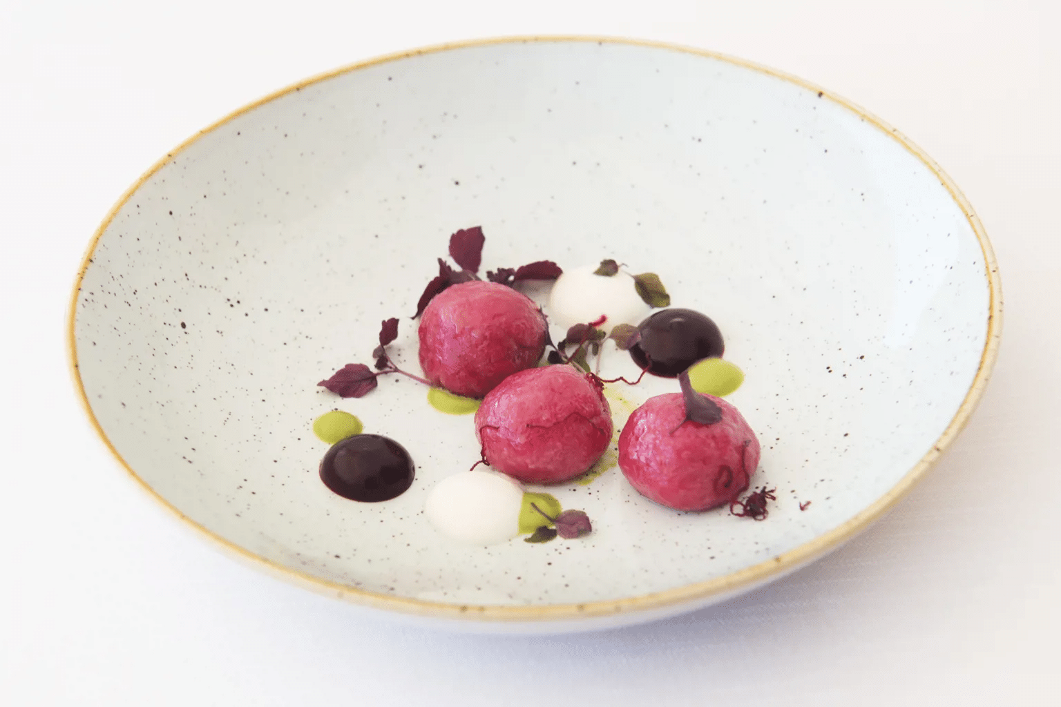 Pink gnocchi with a green core and ricotta cream